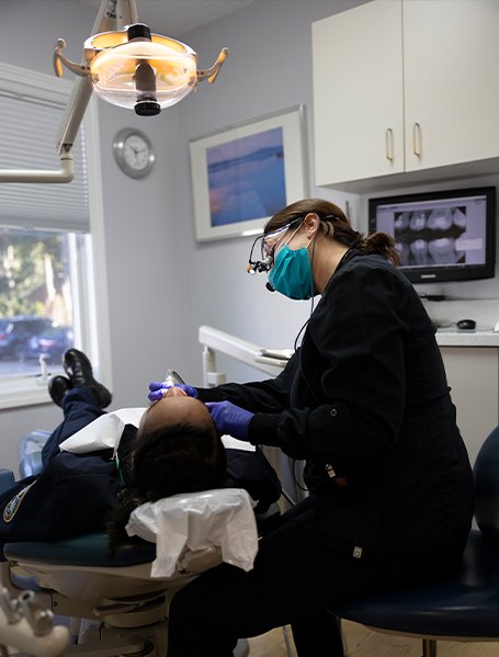 Dental team member examining dental patient