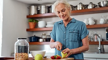 Woman smiling while preparing snack in kitchen