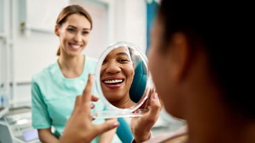 Patient smiling at reflection in treatment chair