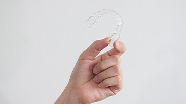 Closeup of patient holding clear aligner