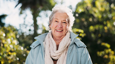 Woman smiling with foliage behind her