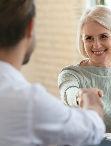 Woman smiling and shaking hands with her dentist