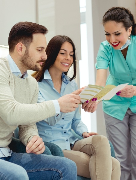 Dental team member giving patient in house membership informaiton