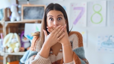 Woman with knocked out tooth covering her mouth