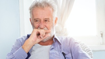 Man with lost dental crown covering his mouth