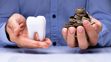 Two hands holding tooth and coins 