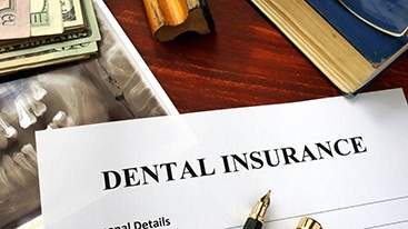 Dental insurance paperwork on wooden desk 
