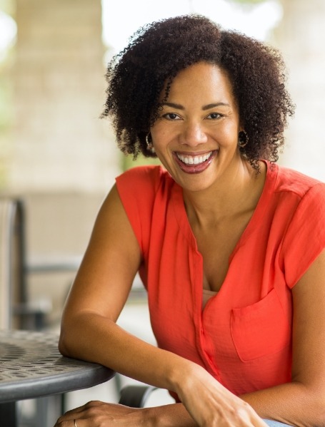 Woman smiling after dental implant tooth replacement