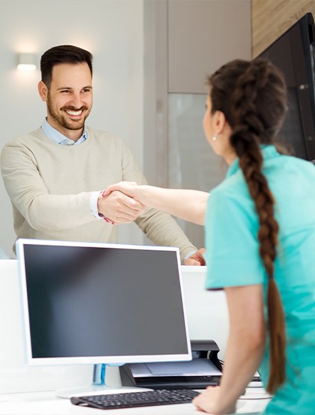 Man discussing dental insurance coverage with dental team member