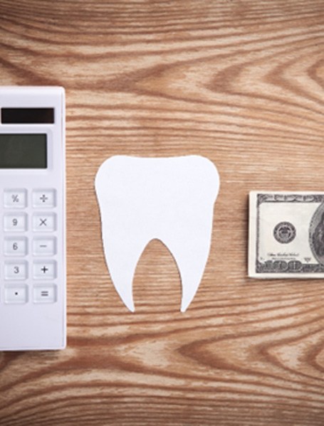 dollar bill and tooth and calculator for cost of Invisalign in Hamden