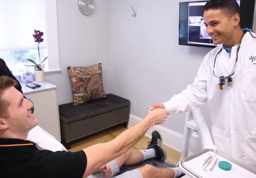 Doctor D'Andrea shaking hands with dental patient