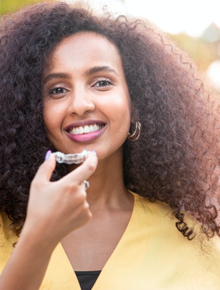 Woman placing an Invisalign clear aligner