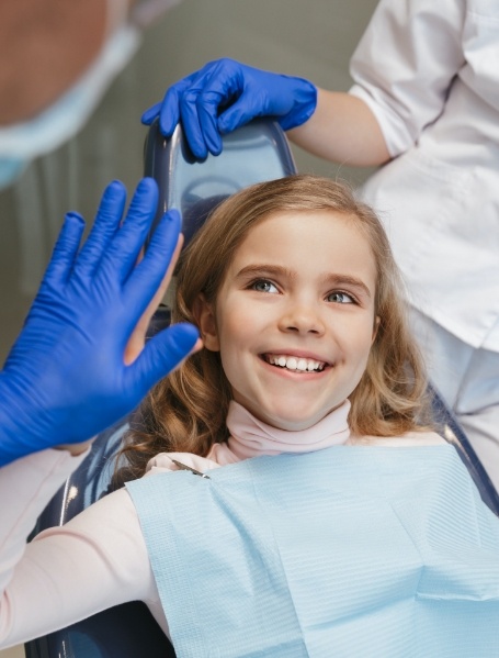 Smiling young patient during children's dentistry checkup and teeth cleaning