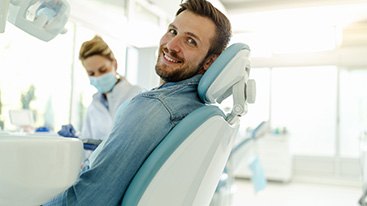 Man smiling while sitting in treatment chair