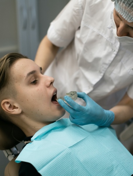 Dentist fitting teen's custom sportsguard