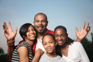 family of four smiling hugging