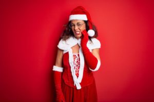 woman in Santa suit with tooth pain
