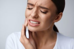 Woman in pain needing an emergency dentist in Hamden.