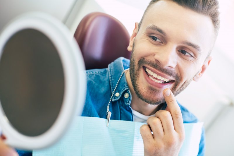 Patient with veneers smiling at reflection