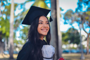 Smiling woman in black graduation cap and gown